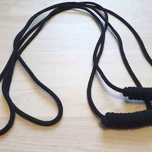 May include: Black resistance bands with padded handles. The bands are made of a thick, durable material and are designed for strength training and exercise. The handles are wrapped for a comfortable grip.