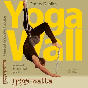 May include: A yellow and brown book cover with the title "Yoga Wall" and the text "A manual for Yoga Wall practice" in a brown font. The cover also features a person doing a yoga pose with ropes attached to their legs.