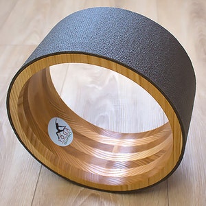 ECO Wooden Yoga Wheel covered with gray yoga mat