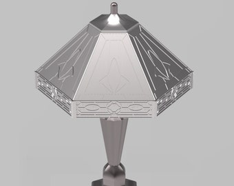 Op de afbeelding: Een zilveren tafellamp met een geometrisch gepatroneerde kap en een zeshoekige voet.