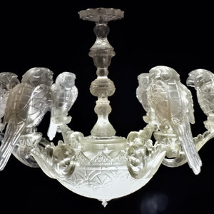 May include: A crystal chandelier with a clear glass design featuring five birds perched on the branches. The chandelier has a bowl-shaped base with intricate details.