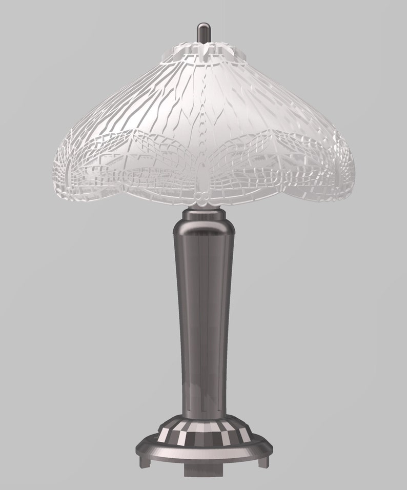 Pode incluir: Um abajur de mesa de vidro branco com um design de lib&eacute;lula na c&uacute;pula. A l&acirc;mpada tem uma base de metal prateada.