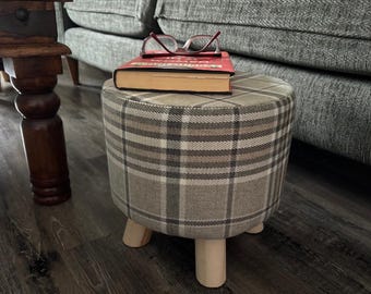 Taburete tapizado a mano con tartán gris, patas de madera y funda lavable.