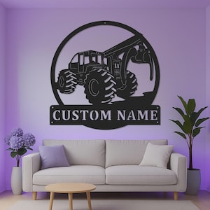 Op de afbeelding: Een zwart metalen wandbord met een cirkelvormig frame en het silhouet van een bosbouwtrekker met een grijper. Onder de tractor bevindt zich een rechthoekige banner met de uitgesneden tekst CUSTOM NAME in een vetgedrukt lettertype.
