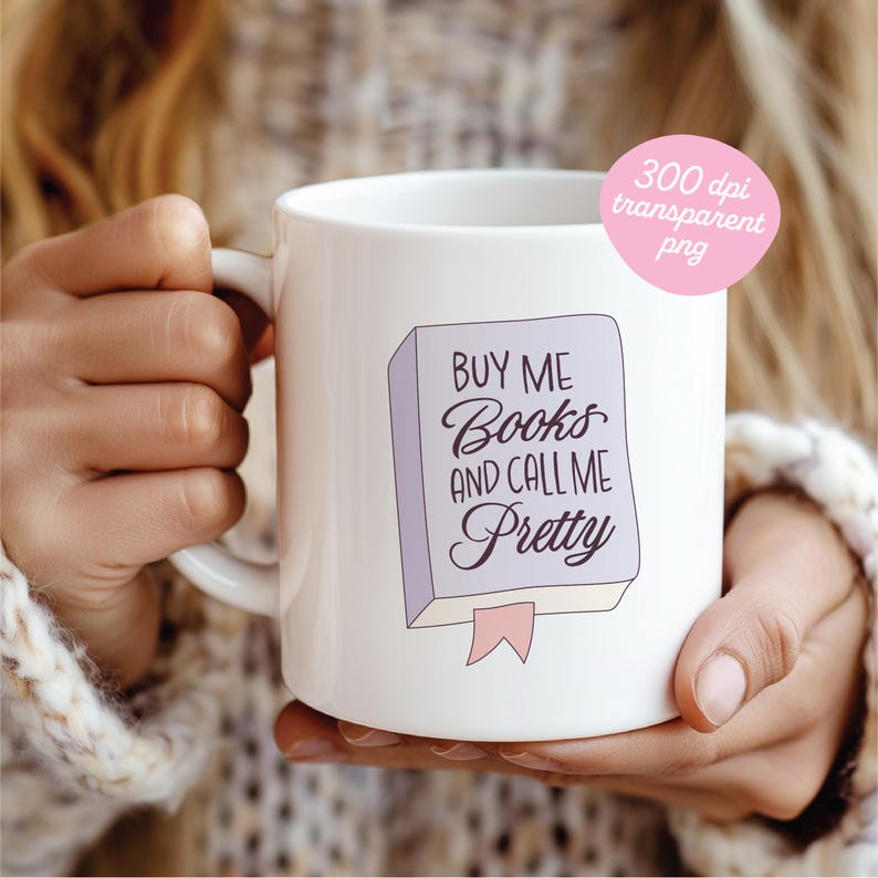 May include: White ceramic mug featuring the text "Buy Me Books and Call Me Pretty" in a whimsical font, with a light purple book illustration and pink ribbon bookmark. The mug is held by a person.