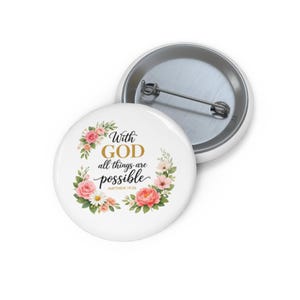 Puede incluir: Pin blanco con el texto "With GOD all things are possible" en escritura dorada y negra, rodeado por una corona floral de rosas rosas y melocotón y vegetación. Un segundo pin es visible en el fondo.
