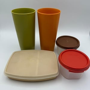 Puede incluir: Una colección de recipientes y vasos Tupperware vintage en varios colores. Incluye dos vasos altos verdes y naranjas, un recipiente rectangular beige y dos recipientes pequeños con tapas marrones y rojas. Los artículos son de plástico.