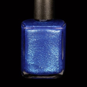 May include: A bottle of blue nail polish with a shimmering, glittery finish. The square bottle has a black cap. The nail polish is a vibrant, eye-catching color, perfect for a manicure or pedicure.