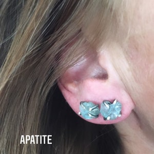 Pu&ograve; includere: Un paio di orecchini d'argento con pietre di apatite blu chiaro. Gli orecchini hanno la forma di un gruppo di piccole pietre.