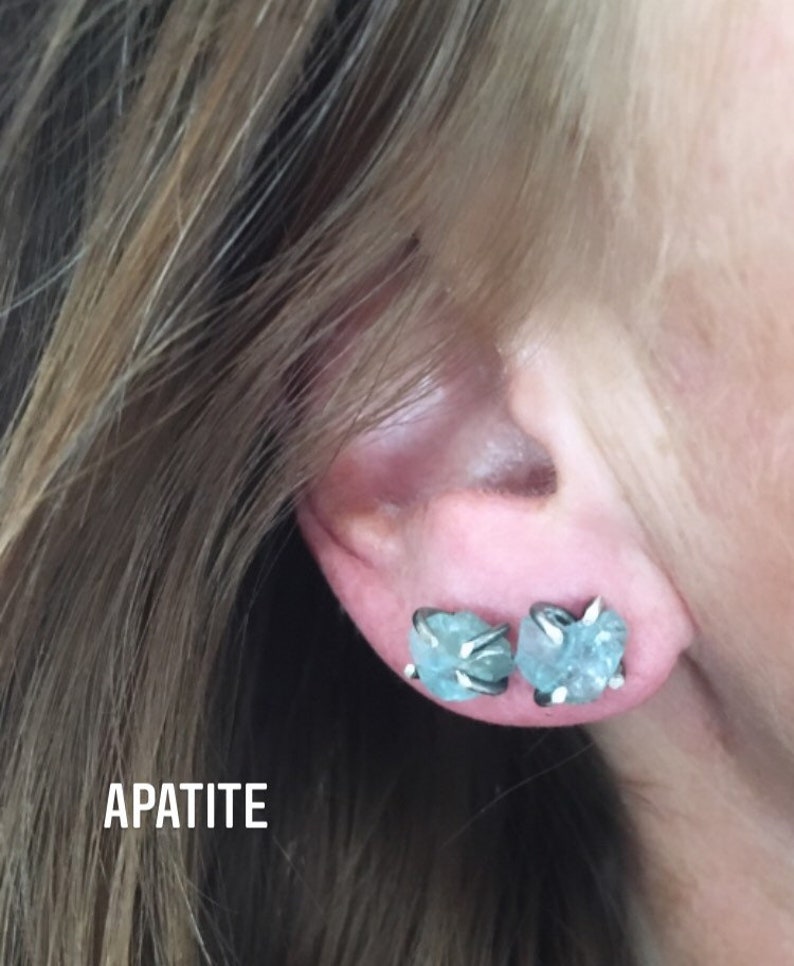 Pu&ograve; includere: Un paio di orecchini d'argento con pietre di apatite blu chiaro. Gli orecchini hanno la forma di un gruppo di piccole pietre.