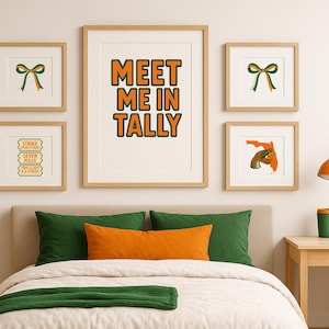 May include: A collection of framed art prints with a Florida theme. The central print reads "MEET ME IN TALLY" in orange and black. Other prints feature a bow, a map of Florida with a snake, and text that reads "STRIKE, SEVEN HILLS, TWO CLAPS & A STRIKE".