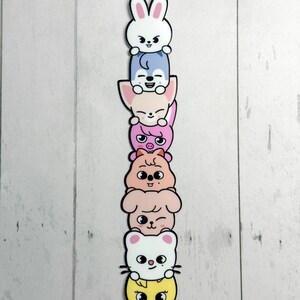 May include: A colourful stack of seven cartoon animal characters. The characters are a white bunny, a blue fox, a pink fox, a pink pig, a tan hamster, a pink dog, a white cat, and a yellow chick, each with a black outline.