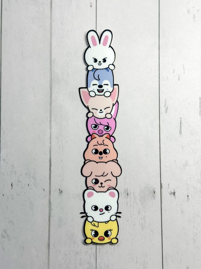 May include: A colourful stack of seven cartoon animal characters. The characters are a white bunny, a blue fox, a pink fox, a pink pig, a tan hamster, a pink dog, a white cat, and a yellow chick, each with a black outline.