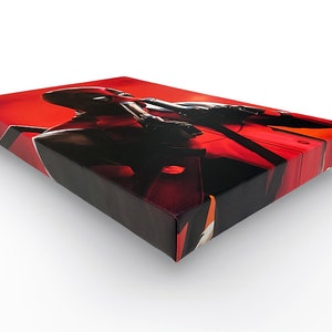 May include: A red and black canvas print featuring a superhero character with a red and black suit and a red background.