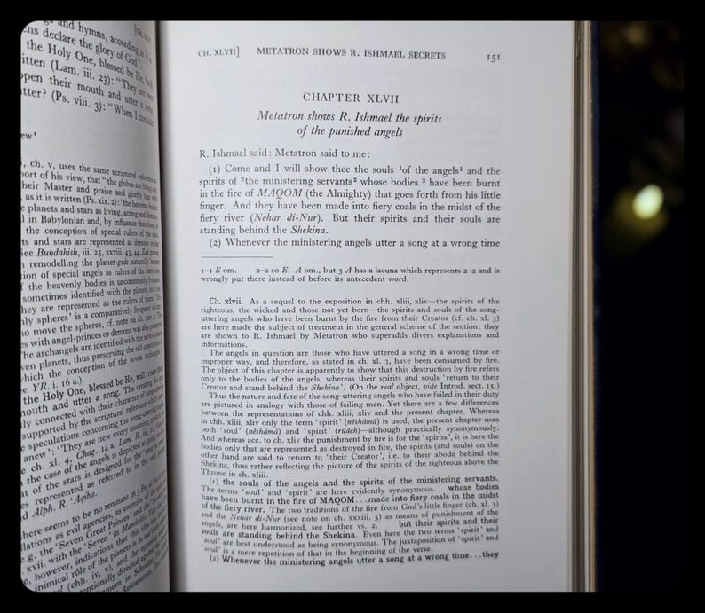 May include: An open book displaying text on the right-hand page, with the title "CHAPTER XLVII" and the subtitle "Metatron shows R. Ishmael the spirits of the punished angels." The left page also has text. The book is open.
