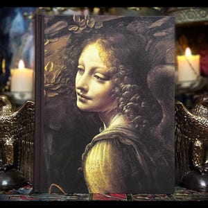 May include: A vintage book cover featuring a painting of a woman with long, curly brown hair. The woman is looking to the left, and her face is illuminated by a soft, golden light. The background is a dark, shadowy forest.