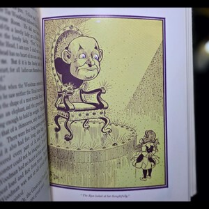 Puede incluir: Ilustraci&oacute;n de un libro que muestra una figura de cabeza grande sentada en una silla ornamentada, frente a una figura peque&ntilde;a. La imagen es en tonos amarillos y morados, con el texto "The Ripe looked at her thoughtfully."