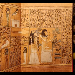 以下が含まれることがあります： ヒエログリフのテキストの前に立っている2人の女性を描いた、古代エジプトのパピルスのスクロールの詳細なイラスト。女性は伝統的なエジプトの服装をし、杖を持っています。スクロールは茶色、黄色、白の色合いです。