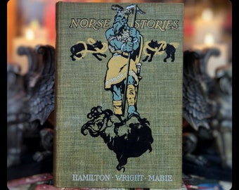 May include: A vintage book cover with a green background and the title "NORSE STORIES" in black lettering. The cover features an illustration of a warrior with a sword and shield, standing on a rock with two wolves in the background. The author names "HAMILTON - WRIGHT - MABIE" are printed at the bottom of the cover.