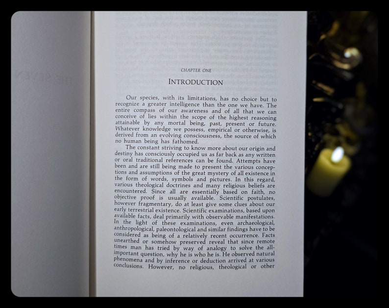 Pode incluir: Uma p&aacute;gina de um livro intitulado "Introdu&ccedil;&atilde;o" com texto sobre a origem e o destino da humanidade. O texto discute as limita&ccedil;&otilde;es do conhecimento humano e a busca por respostas a quest&otilde;es fundamentais sobre a exist&ecirc;ncia. A p&aacute;gina &eacute; iluminada por uma vela.