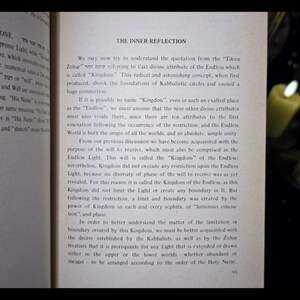 K&ouml;nnte beinhalten: Offenes Buch mit dem Titel "The Inner Reflection" und Seitenzahl 91. Der Text behandelt kabbalistische Konzepte, mit Fokus auf "Kingdom" und "Endless Light". Der Hintergrund ist dunkel mit brennenden Kerzen.