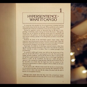 May include: A book with the title "Hypersentience - What It Can Do" and the number "1" on the top right corner. The book is open to a page with text about hypersensitivity and how it can affect people's lives.