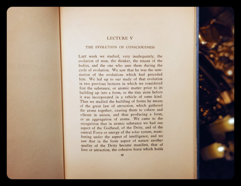 May include: A page from a vintage book with the title "Lecture V: The Evolution of Consciousness". The text discusses the evolution of man and the role of atoms in forming matter.