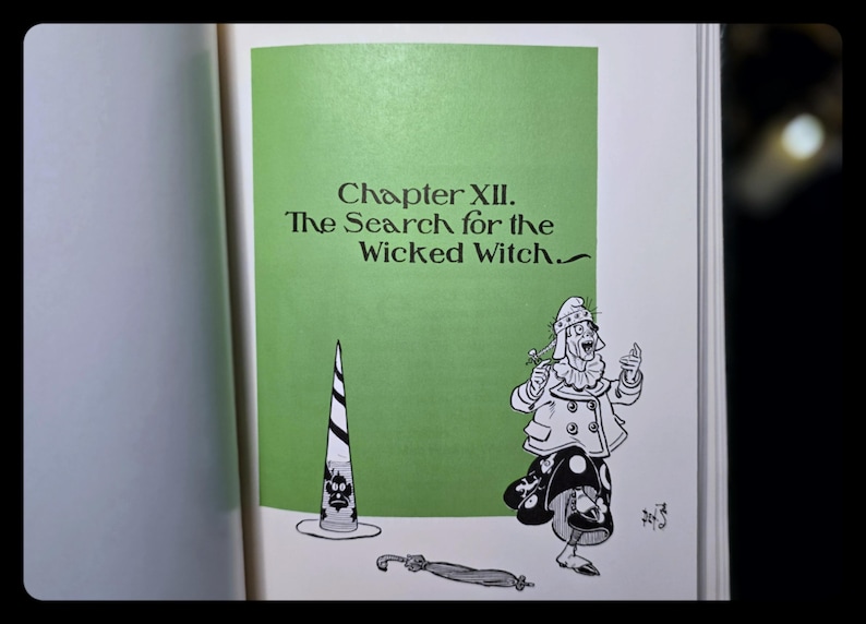 Puede incluir: Ilustraci&oacute;n de libro con el texto "Cap&iacute;tulo XII. La b&uacute;squeda de la bruja malvada." Un personaje de dibujos animados con sombrero y varita est&aacute; junto a un sombrero a rayas. Fondo verde.