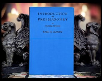 May include: A blue hardcover book titled "Introduction to Freemasonry" by Master Mason Carl H. Claudy.