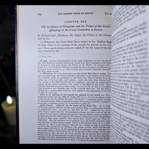 May include: An open book displaying text from "The Hebrew Book of Enoch." Chapter XXX is visible, discussing the 72 princes of Kingdoms. The text is in black font on off-white paper. The book is open, with the pages slightly curved.