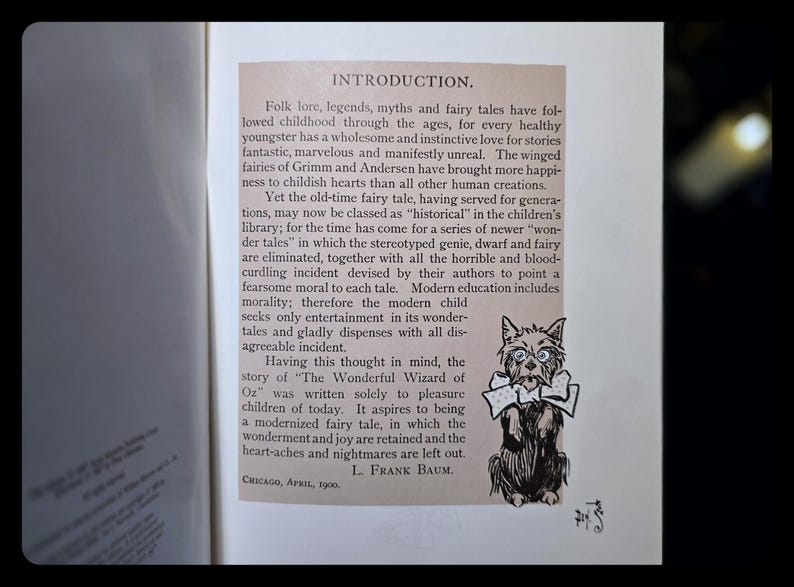 Puede incluir: P&aacute;gina de libro abierta con el t&iacute;tulo "INTRODUCTION" y texto sobre cuentos de hadas. Una ilustraci&oacute;n en blanco y negro de un perro con gafas y pajarita est&aacute; en el lado derecho. El libro es de Chicago, abril de 1900.