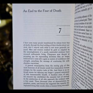 May include: Open book with the title "An End to the Fear of Death" and the number 7. The text is in black font on white pages. The book is open to a page of text.