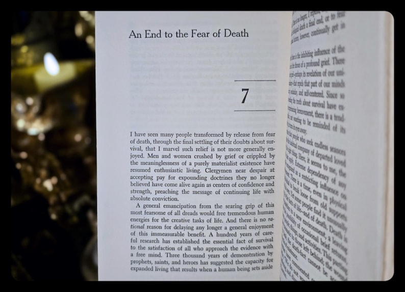 May include: Open book with the title "An End to the Fear of Death" and the number 7. The text is in black font on white pages. The book is open to a page of text.