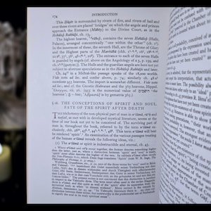 May include: An open book with English text, showing the title "INTRODUCTION" at the top of the page. The pages are slightly yellowed. A candle is visible in the background, providing soft lighting.