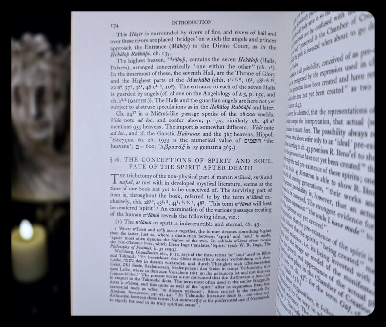 May include: An open book with English text, showing the title "INTRODUCTION" at the top of the page. The pages are slightly yellowed. A candle is visible in the background, providing soft lighting.