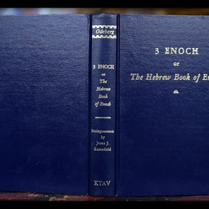 May include: A dark blue hardcover book, titled "3 Enoch or The Hebrew Book of Enoch", with gold lettering. The spine displays the title, author, and publisher, "KTAV". The book is held open, revealing the title.