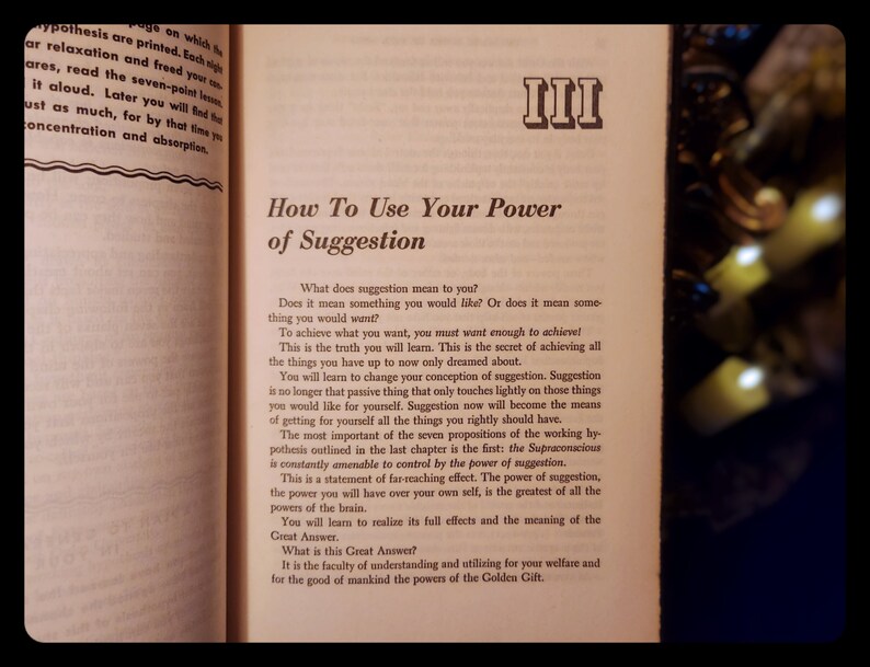 May include: A book titled "How To Use Your Power of Suggestion" with the Roman numeral III on the cover. The book is open to a page with text about the power of suggestion and how to use it to achieve your goals.