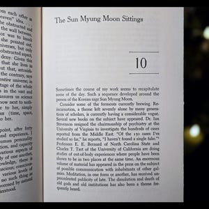 May include: Open book page with text titled "The Sun Myung Moon Sittings" and the number "10". The text discusses reincarnation, out-of-body experiences, and meditation. The page is yellowed with age.