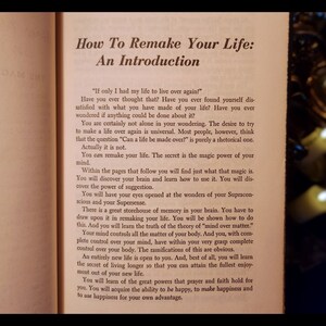 May include: A close-up of a book titled "How To Remake Your Life: An Introduction". The book is open to a page with text about the power of the mind and how to use it to remake your life.