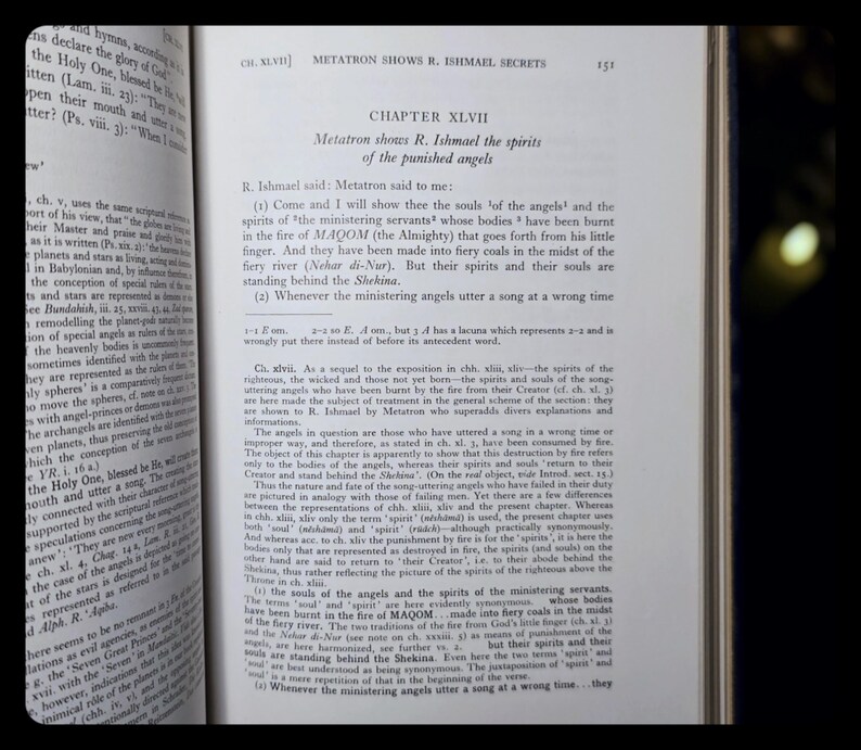 May include: An open book displaying text on the right-hand page, with the title "CHAPTER XLVII" and the subheading "Metatron shows R. Ishmael the spirits of the punished angels." The left page also has text. The book's pages are slightly yellowed.