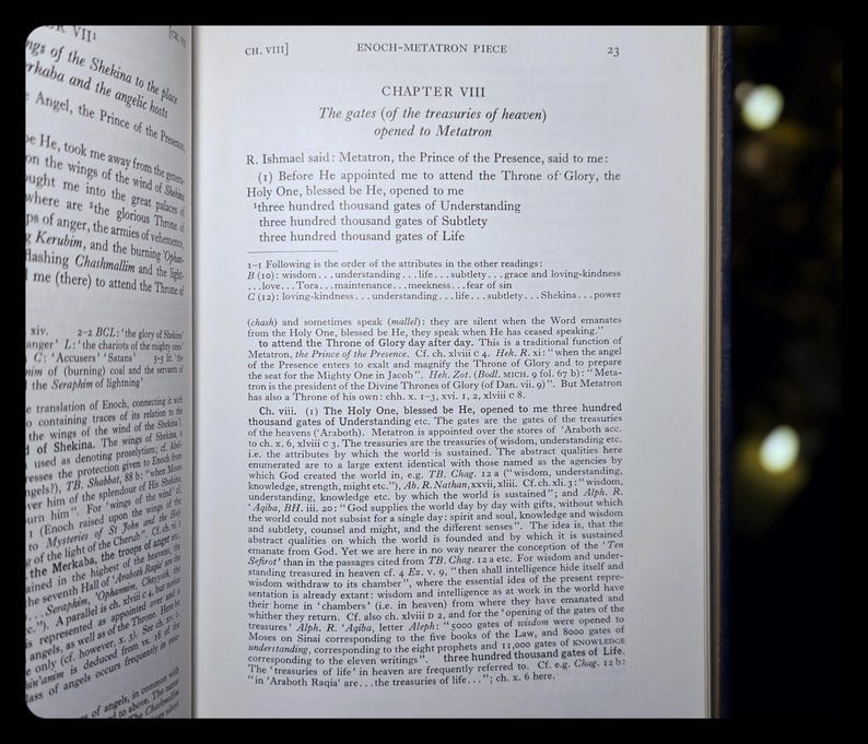 May include: An open book with text, featuring the title "ENOCH-METATRON PIECE" and the chapter heading "CHAPTER VIII". The pages display detailed text, likely from a religious or historical text, with a dark background.