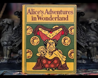 May include: A vintage hardcover book with a yellow cover and green and gold illustrations. The title is "Alice's Adventures in Wonderland".