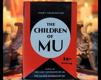 Op de afbeelding: Een rood boek met zwarte tekst met de titel "The Children of Mu" van James Churchward. Het boek is de 16e druk en gaat over het verloren continent Mu.