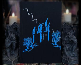 Puede incluir: Una cubierta de libro negra con una silueta azul de un castillo y dos árboles. Un rayo está dibujado en blanco sobre el castillo.