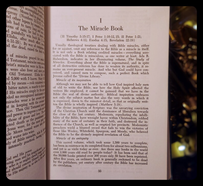 Może przedstawiać: Antyczna książka zatytułowana "The Miracle Book" z brązową sk&oacute;rzaną okładką i złotymi literami. Książka omawia inspirację i starożytność Biblii.