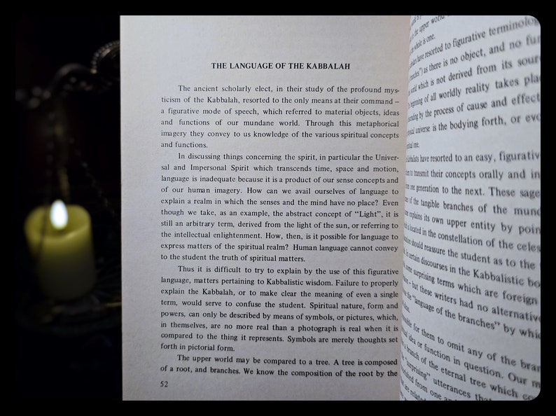 K&ouml;nnte beinhalten: Offenes Buch mit dem Titel "THE LANGUAGE OF THE KABBALAH" und einer brennenden Kerze im Hintergrund. Der Text behandelt die Verwendung von bildhafter Sprache und Symbolen in der Kabbala zur Vermittlung spiritueller Konzepte.