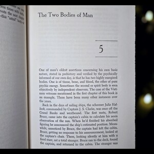 May include: Open book page with text titled "The Two Bodies of Man" and the number "5". The text describes the concept of two human bodies, one physical and one energetic, with examples from history.