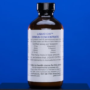 May include: A brown glass bottle with a black cap, labeled "LIQUID CHI™ ORMUS CONCENTRATE." The label lists mineral content per teaspoon, including magnesium, potassium, silicon, and sodium. The bottle is against a blue background.