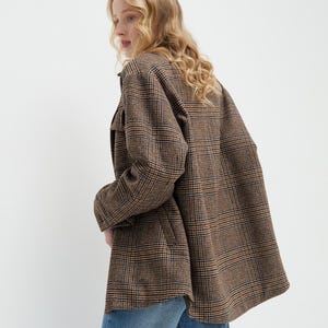 Brown, dark brown and beige checkered fall winter warm shirt jacket with warm lining, long sleeves and pockets.