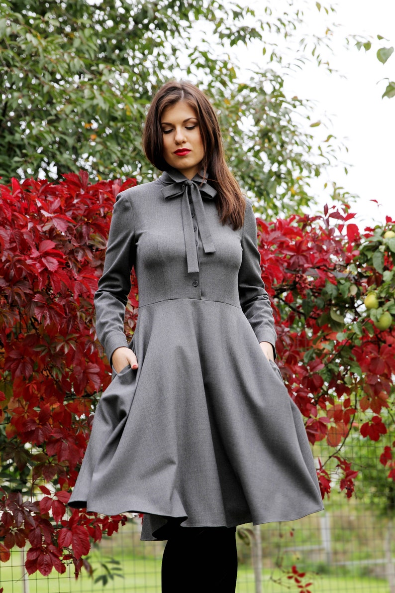 Elegant wool button up shirt dress with long sleeves. This midi dress is fitted at the top and has a flare skirt with side seam pockets.
